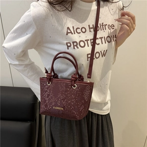 Minimalist wine red bucket bag with snakeskin texture and knotted top handles