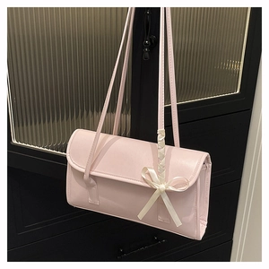 Detail of light pink PU leather shoulder bag featuring creamy ribbon bow and flap closure