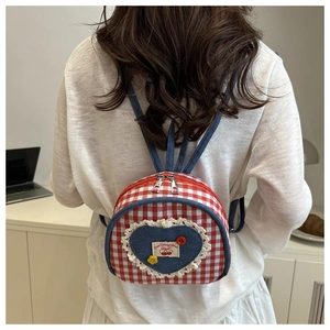 Detailed close-up of a mini plaid backpack featuring heart-shaped denim and lace accents