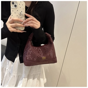 Détails de la texture serpent bordeaux et du logo doré sur ce mini sac à main