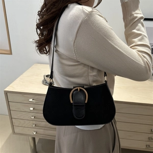 Minimalist black matte underarm bag with gold horseshoe buckle worn on model