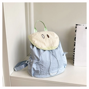 Detail of pear-shaped light blue backpack showing side drawstring pocket and print