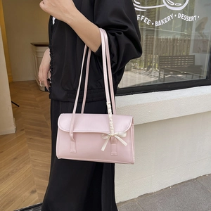 Pink minimalist leather shoulder bag with white satin bow detail for summer style
