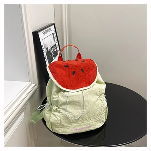 Detail of watermelon-themed backpack featuring textured fabric and red seed patterns