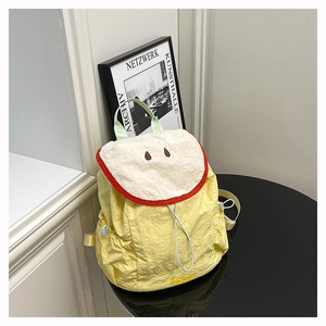 Detailed view of the yellow nylon apple backpack with embroidered fruit core and brand logo