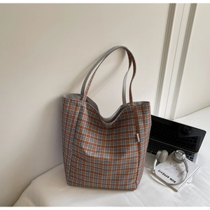 Detail of a large orange and blue checkered tote bag with a soft canvas texture