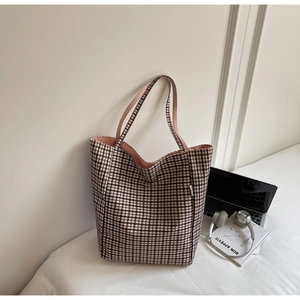 Detailed view of checkered tote bag with pink lining and casual office lifestyle items
