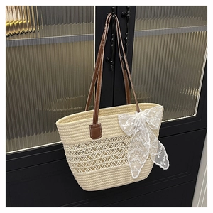 Detailed weave pattern of cream straw tote bag featuring elegant lace bow and leather straps