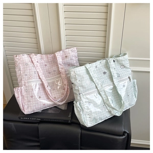 Detail of checkered canvas tote bag with transparent front pocket and star pattern