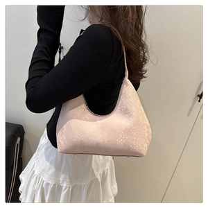 Detail of light pink hobo bag showing refined snake skin texture and curved silhouette