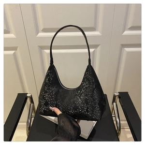 Close-up of black hobo bag featuring premium snake skin embossed texture and moon shape