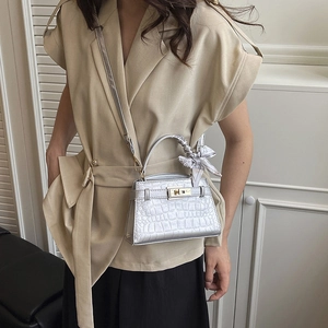 Silver crocodile textured crossbody handbag with decorative scarf on the handle