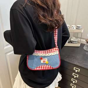 Sweet denim crossbody bag with cherry embroidery and gingham trim worn by a model