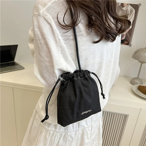 Women's black denim drawstring bucket bag with leather strap and metal logo