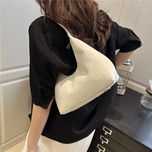 Off-white crescent shoulder bag with snake pattern texture, shown in lifestyle setting