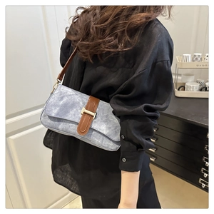 Gros plan du sac baguette rétro bleu ciel avec bandoulière en cuir brun et boucle dorée