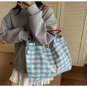 Blue and white gingham canvas tote bag with red drawstring rope handles and woven label