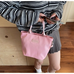 Primo piano della borsa in nylon rosa con etichetta fashion e dettaglio della zip