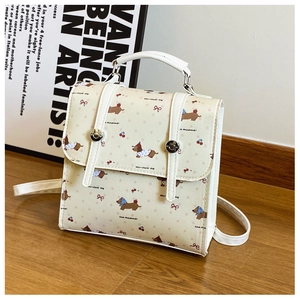 Detail of cream backpack with dachshund print, cherry patterns and silver hardware