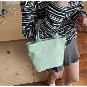 Dettaglio della borsa in nylon verde menta con etichetta Fashion e chiusura lampo