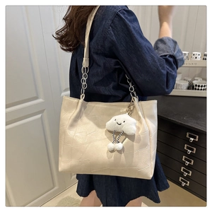 Détail du sac cabas beige en cuir souple avec coutures et charm nuage peluche