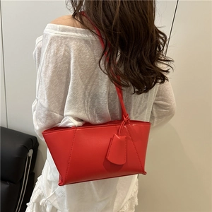 Minimalist red leather tote bag for women shown from a stylish shoulder perspective