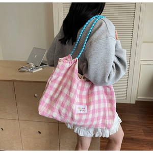 Detailed close-up of a pink and white plaid tote bag with blue woven rope handle
