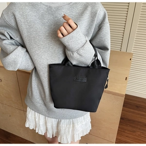 Dettaglio della borsa tote in nylon nero con etichetta in pelle Fashion e zip