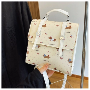 Close-up of cute dachshund and cherry print on a cream-colored square crossbody bag