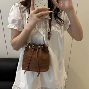Brown frosted leather drawstring bucket bag for women with metal eyelets and crossbody strap