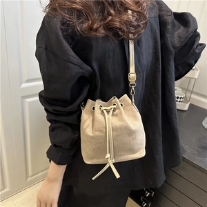 Stylish beige wool tweed bucket bag for women with leather drawstring and gold hardware
