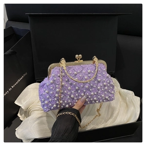 Detail of purple rose textured evening bag with pearl accents and gold chain straps