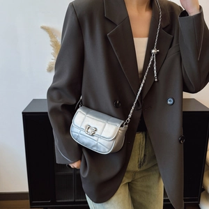 Minimalist silver quilted saddle bag with metal chain strap and G-buckle closure