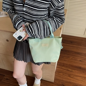 Borsa tote minimalista in nylon verde chiaro con patch fashion in un contesto casual chic