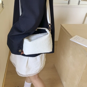 Minimalist white textured crossbody shoulder bag with gold metal hooks and zipper closure
