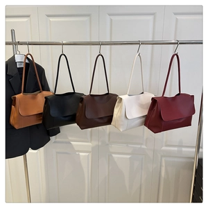 Minimalist faux leather tote bags in five colors displayed on a metal hanger