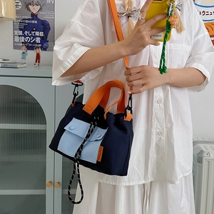Fashionable navy canvas tote bag with orange handles and blue front pockets