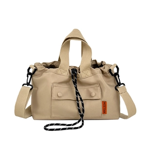 Minimalist khaki nylon tote bag with drawstring closure and detachable shoulder strap