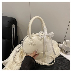 Detail of creamy white crossbody bag with 3D bow texture and elegant lace ribbon