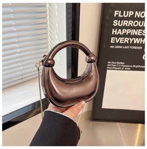 Detail of metallic crescent bag with circular handle and gold chain strap