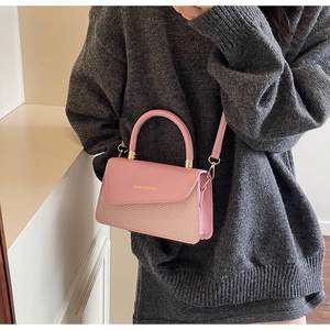 Detail of pink square bag with dual-texture finish, gold hardware and fashion engraving