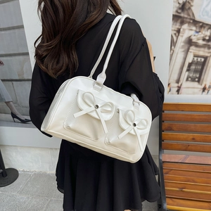 Minimalist white PU leather Boston bag with bow pockets shown in an outdoor street setting