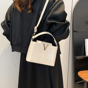 White crocodile pattern crossbody bag with V-shaped metal logo and adjustable strap