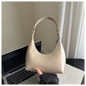 Dettaglio della borsa a croissant in vernice beige lucida con cerniera argentata