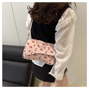 Détail du sac bandoulière rose avec motifs cerises et bandoulière en cuir PU réglable