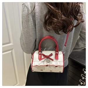 Vue arrière du sac Boston avec nœud rouge, dentelle et pendentif en forme de cœur