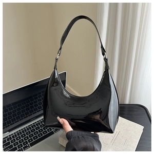 Dettaglio della borsa hobo a mezzaluna in vernice nera lucida con anelli metallici