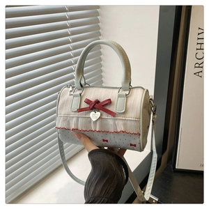 Détail du nœud et du pendentif cœur sur le sac Boston à pois pour femmes