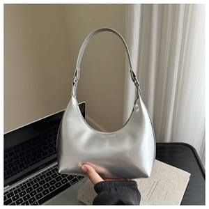 Dettaglio della borsa hobo argento specchiato con superficie metallica lucida