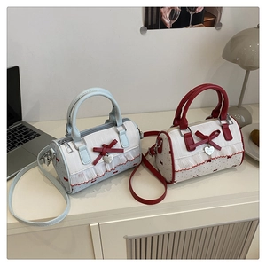 Détail de sacs Boston avec nœuds, dentelle et pendentifs cœur sur un bureau chic